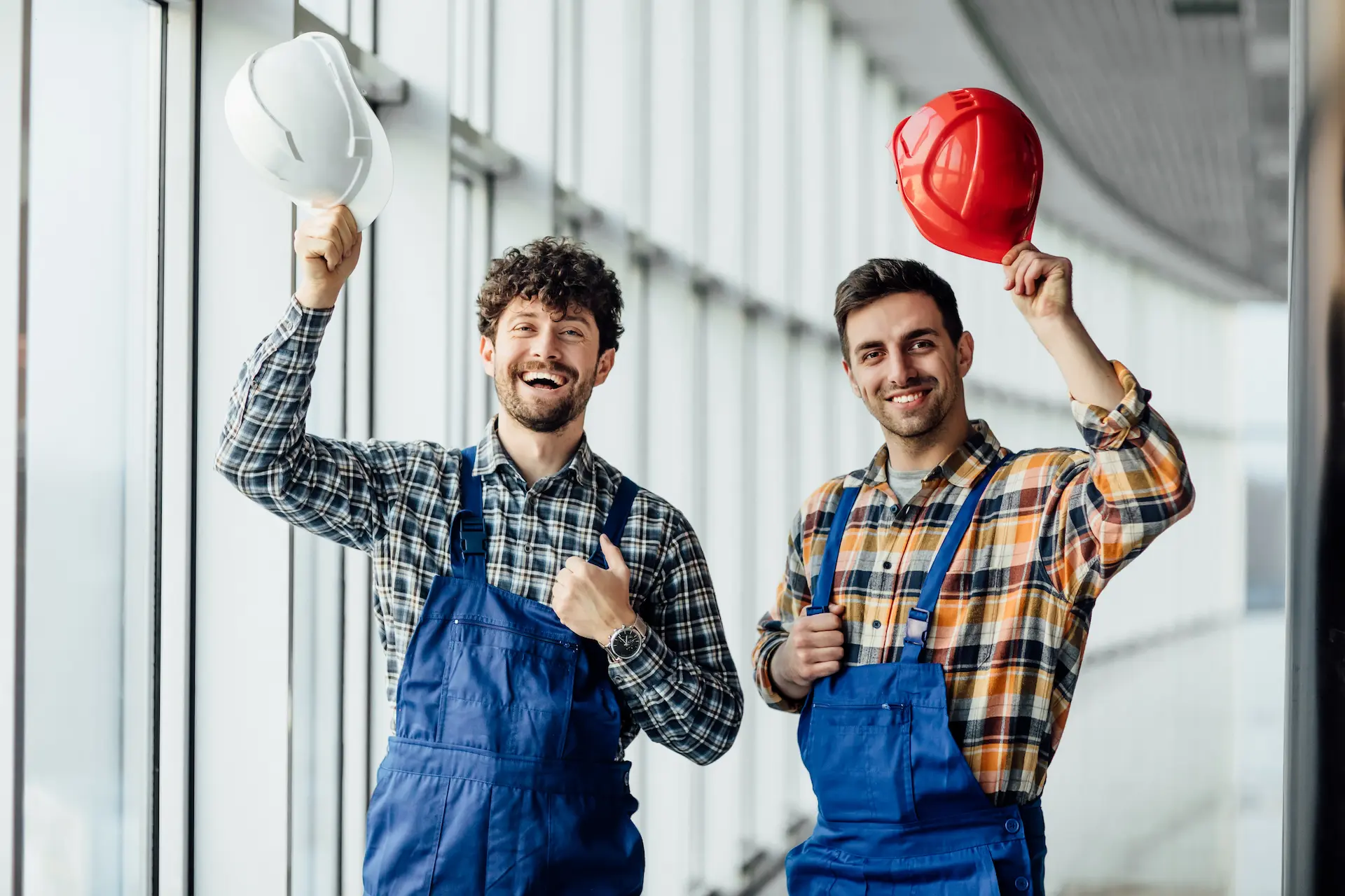 good-looking-construction-worker-sharing-with-experience-with-colleague-holding-helmet